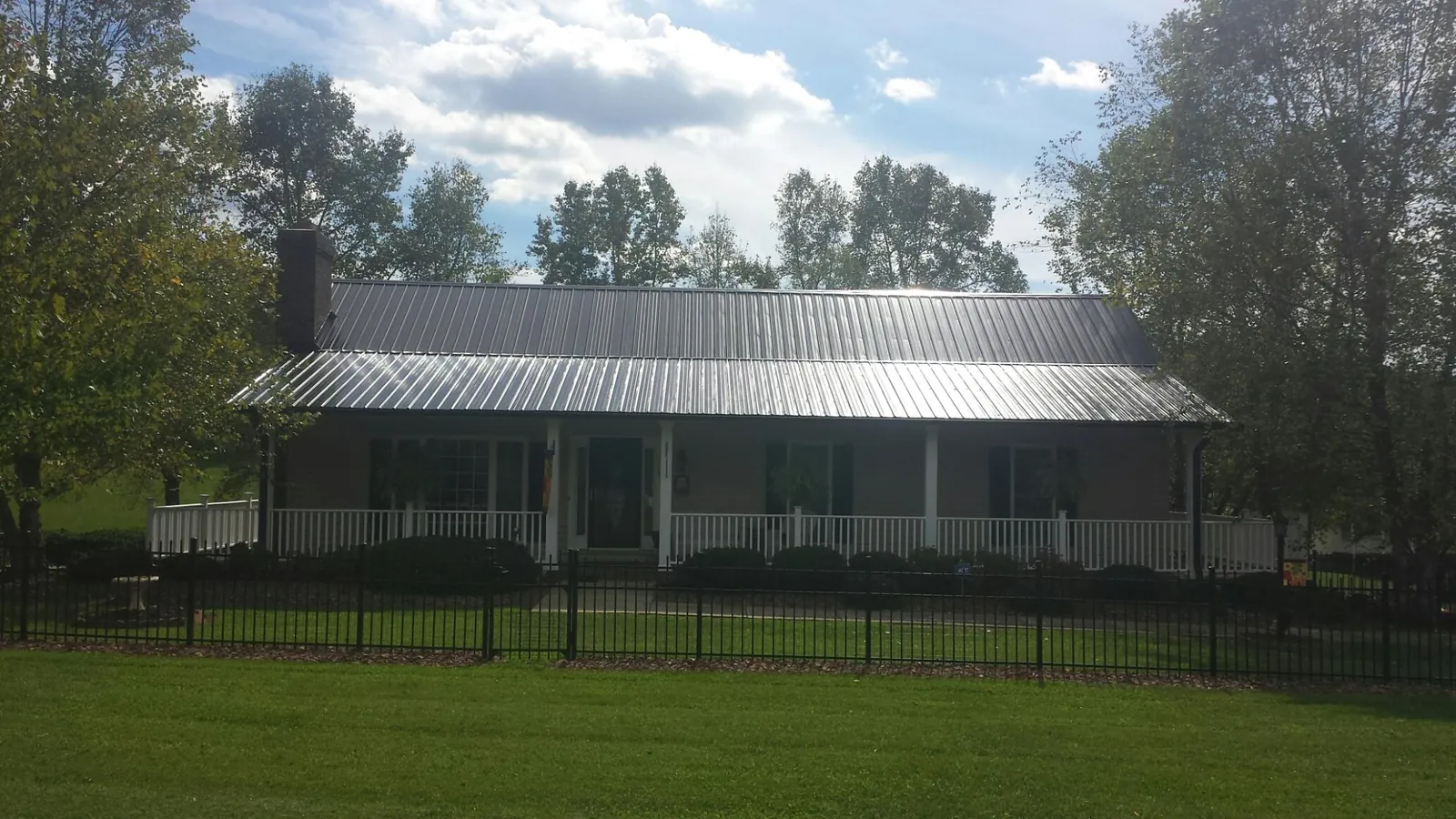 Gray metal roof on a brick ranch with a full width front porch — Gutter Guard Installation work by our crew in Healdsburg
