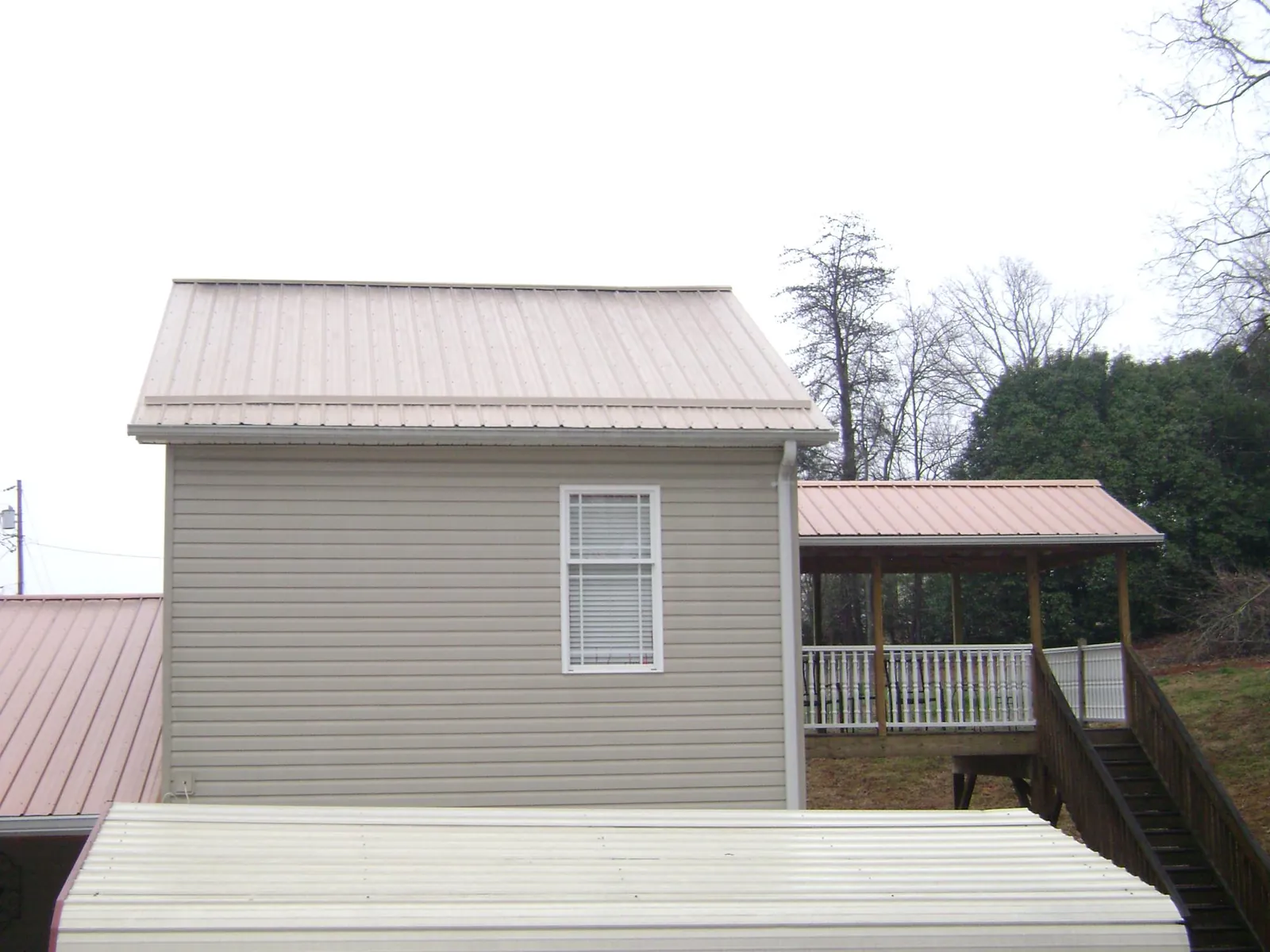 Tan metal roofs on a two story addition and attached porch, from a Roof Replacement job in Healdsburg