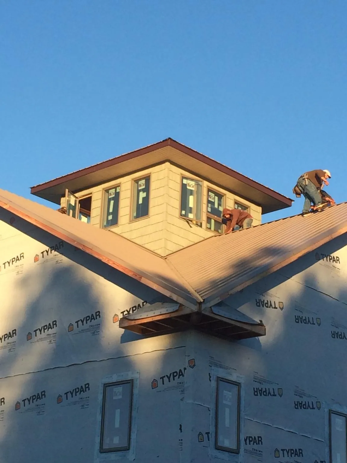 Roofers working around a rooftop cupola on a new metal roof at sunset — Roof Waterproofing in Healdsburg by Roofing Brothers